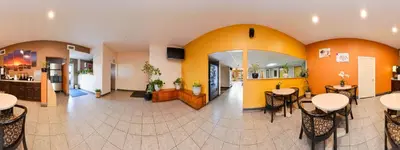 a lobby of a hotel with tables and chairs at Americas Best Value Inn & Suites Madera in Madera