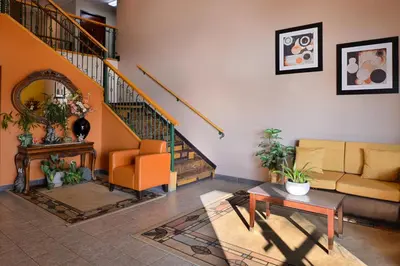 a living room with a couch and a staircase at Americas Best Value Inn & Suites Madera in Madera