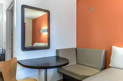 a small table and chair in a room with a mirror at Motel 6-Fresno, CA in Fresno