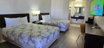 a hotel room with two beds and a flat screen tv at Motel 6-Santa Nella, CA - Los Banos in Santa Nella Village