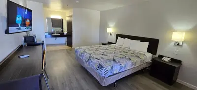 a hotel room with a bed and a flat screen tv at Motel 6-Santa Nella, CA - Los Banos in Santa Nella Village