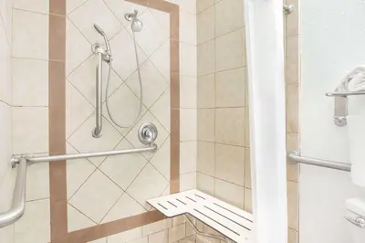 a shower in a bathroom with a glass door at Days Inn by Wyndham Turlock in Turlock