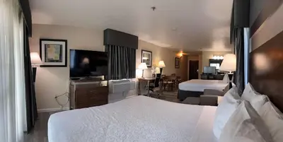 a hotel room with a large bed and a television at Best Western Americana in Dinuba