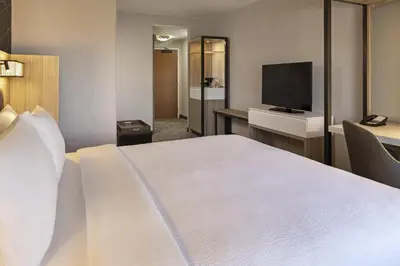 a hotel room with a bed and a flat screen tv at SpringHill Suites by Marriott Turlock in Turlock