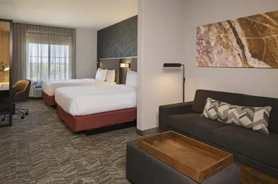 a hotel room with a bed and a couch at SpringHill Suites by Marriott Turlock in Turlock