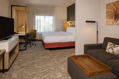 a hotel room with a bed and a living room at SpringHill Suites by Marriott Turlock in Turlock