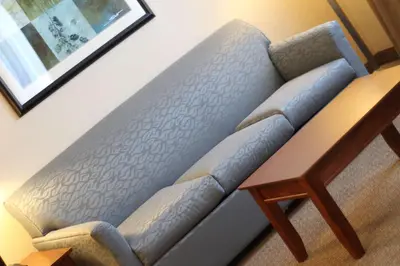 a blue couch in a room with a wooden table at Hampton Inn & Suites Folsom in Folsom