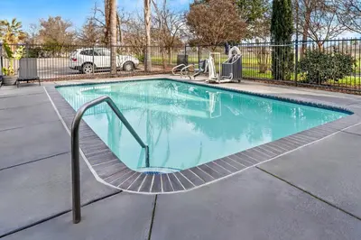 a swimming pool with a slide in a yard at Comfort Suites Clovis - Fresno in Clovis