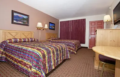 a hotel room with two beds and a table at National 9 Inn - Placerville in Placerville
