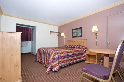 a hotel room with a bed and a table at National 9 Inn - Placerville in Placerville