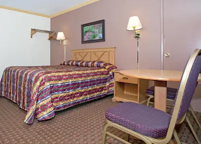 a hotel room with a bed and a table at National 9 Inn - Placerville in Placerville