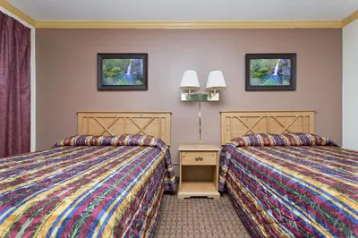 a hotel room with two beds and two windows at National 9 Inn - Placerville in Placerville