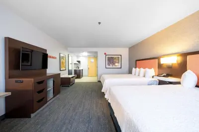 a hotel room with two beds and a flat screen tv at Hampton Inn & Suites Modesto - Salida in Modesto