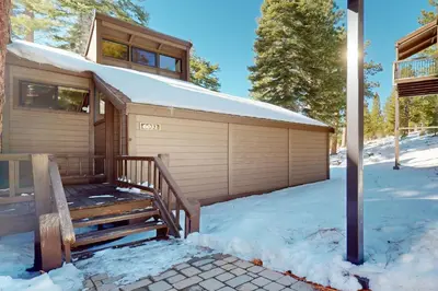 a house with a garage in the snow at Indian Hills Hideaway in Ponderosa Fairway Estates