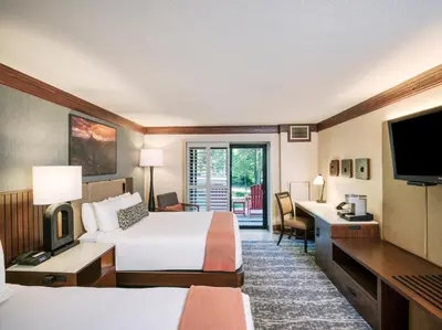 a hotel room with two beds and a television at Tenaya at Yosemite in Fish Camp