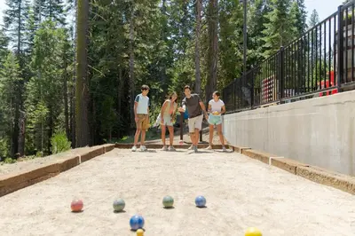 a group of people standing in a sandbox with balls at Tenaya at Yosemite in Fish Camp