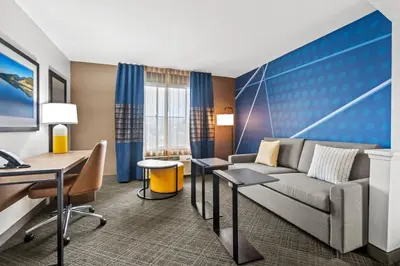 a hotel room with a couch and a desk at Comfort Inn South San Jose - Morgan Hill in Morgan Hill