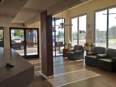 a living room with couches and chairs and windows at Studio 6 Suites Delano, CA in Delano