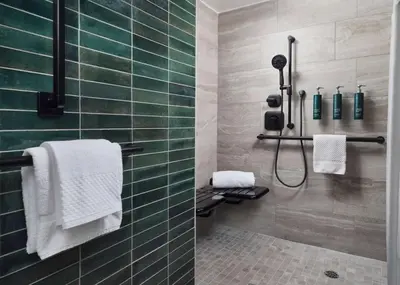 a bathroom with a shower with green tiles at Hilton Stockton in Stockton