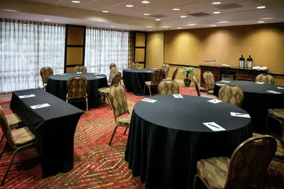 a conference room with tables and chairs and a grand piano at Hilton Stockton in Stockton