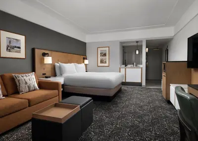 a hotel room with a bed and a couch at Hilton Stockton in Stockton