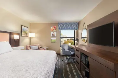 a hotel room with a bed and a flat screen tv at Hampton Inn Tracy in Tracy