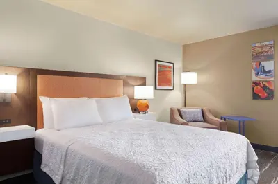 a hotel room with a bed and a chair at Hampton Inn Sacramento/Rancho Cordova in Rancho Cordova