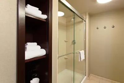 a bathroom with a shower and a glass shower stall at Hampton Inn and Suites Merced in Merced