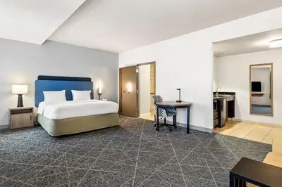 a bedroom with a bed and a desk and a table at Hampton Inn and Suites Merced in Merced