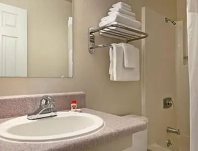 a bathroom with a sink and a mirror and towels at Super 8 by Wyndham Sacramento/Florin Rd in Sacramento