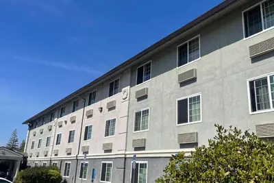 a large gray building with windows on a street at Super 8 by Wyndham Sacramento/Florin Rd in Sacramento