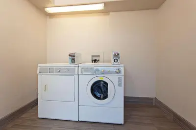 a laundry room with a washing machine and speakers at Days Inn by Wyndham Chowchilla Gateway to Yosemite in Chowchilla