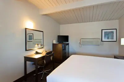 a hotel room with a bed and a desk and a computer at Days Inn by Wyndham Chowchilla Gateway to Yosemite in Chowchilla