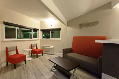 a living room with a couch and two chairs at Days Inn by Wyndham Chowchilla Gateway to Yosemite in Chowchilla