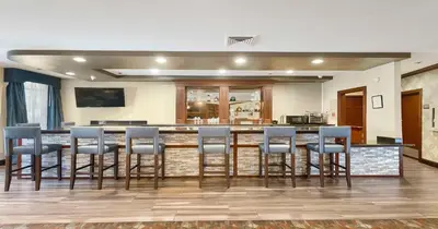 a kitchen with a bar with blue bar stools at Best Western Plus Heritage Inn in Stockton