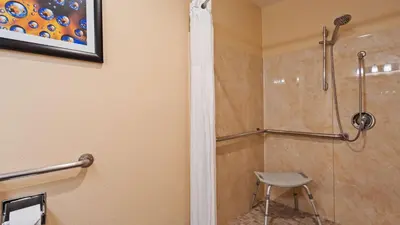 a shower with a stool in a bathroom at Best Western Plus Heritage Inn in Stockton
