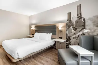 a hotel room with a bed and a chair at Best Western Plus Vineyard Inn in Livermore