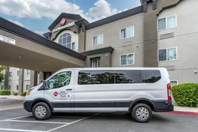a white van parked in a parking lot in front of a building at Best Western Plus Vineyard Inn in Livermore