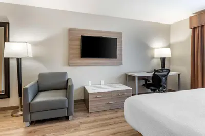 a hotel room with a bed and a chair and a television at Best Western Plus Vineyard Inn in Livermore