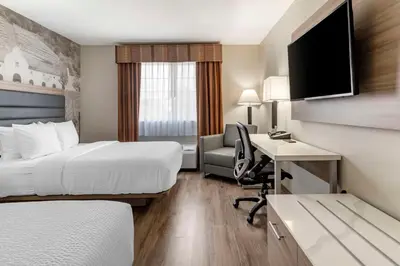 a hotel room with a bed and a desk with a computer at Best Western Plus Vineyard Inn in Livermore