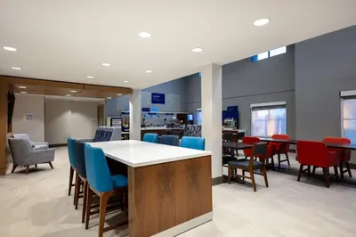a lobby with chairs and tables and a bar at Holiday Inn Express Turlock by IHG in Turlock