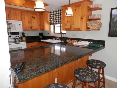 a kitchen with wooden cabinets and a counter with stools at Rr-interlaken 05 in June Lake