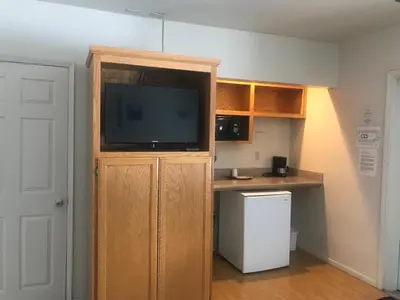 a room with a entertainment center with a flat screen tv at Sunrise Inn in Turlock
