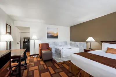 a hotel room with a bed and a desk at Days Inn & Suites by Wyndham Lodi in Lodi