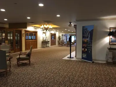 a lobby with a waiting area with chairs and tables at Piccadilly Inn Airport in Fresno