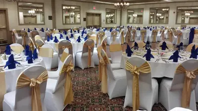 a room filled with tables and chairs with bows at Piccadilly Inn Airport in Fresno
