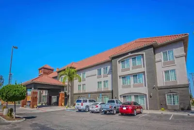a apartment building with cars parked in a parking lot at La Quinta by Wyndham Fowler in Fowler