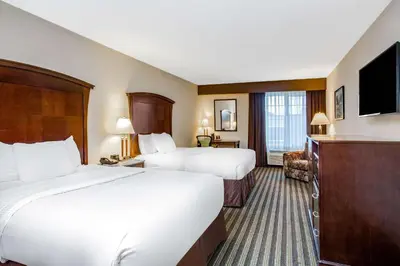 a hotel room with two beds and a flat screen tv at La Quinta by Wyndham Fowler in Fowler