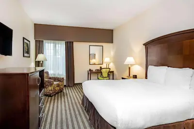 a hotel room with a large bed and a television at La Quinta by Wyndham Fowler in Fowler