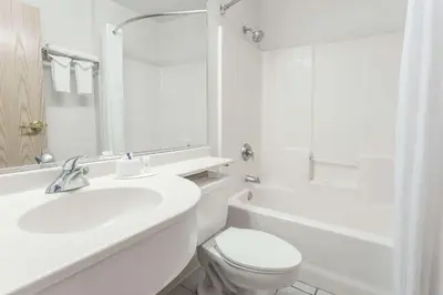 a white bathroom with a sink and a toilet at Microtel Inn & Suites Modesto in Ceres